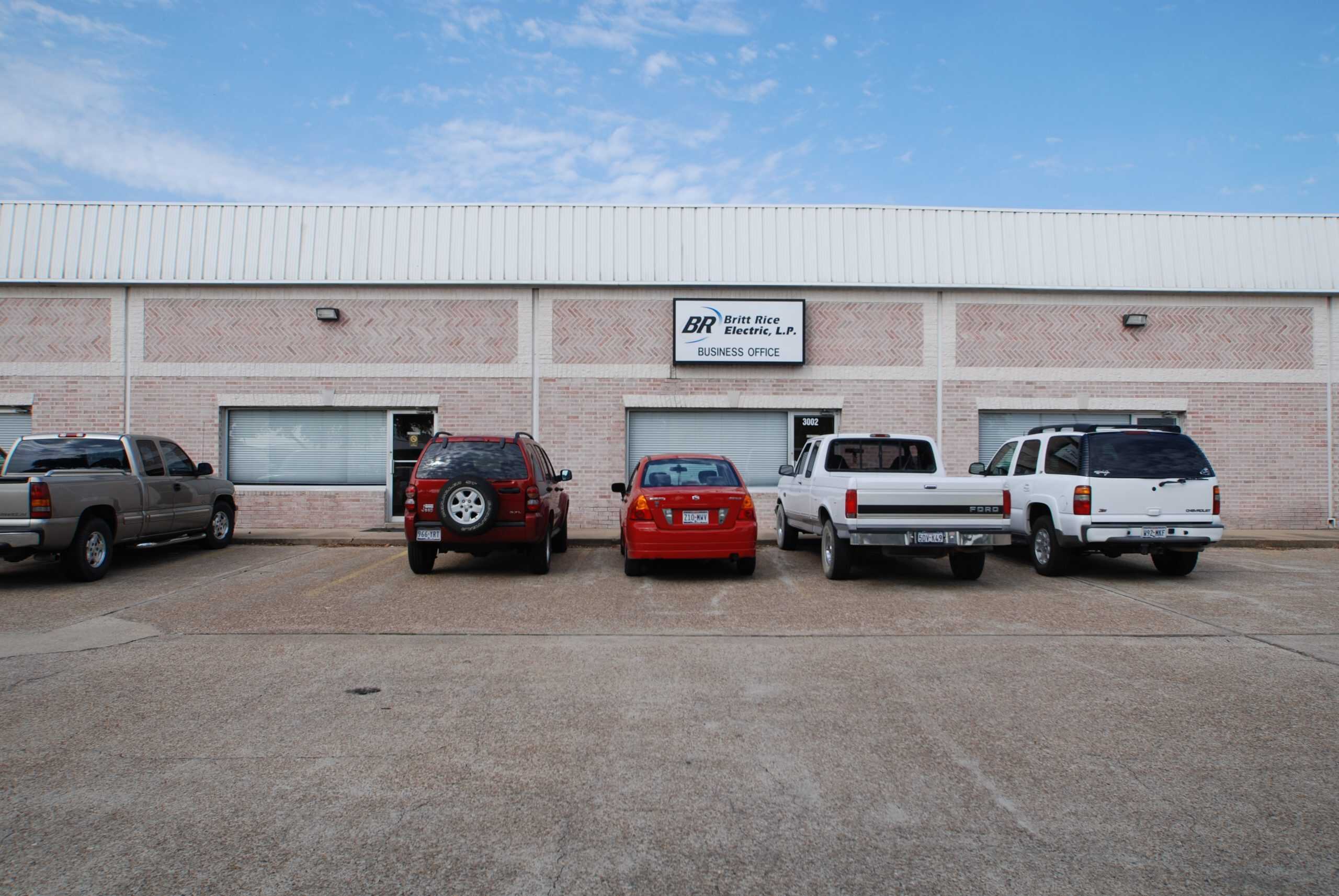 Professional electrical service office with parking lot and company signage.
