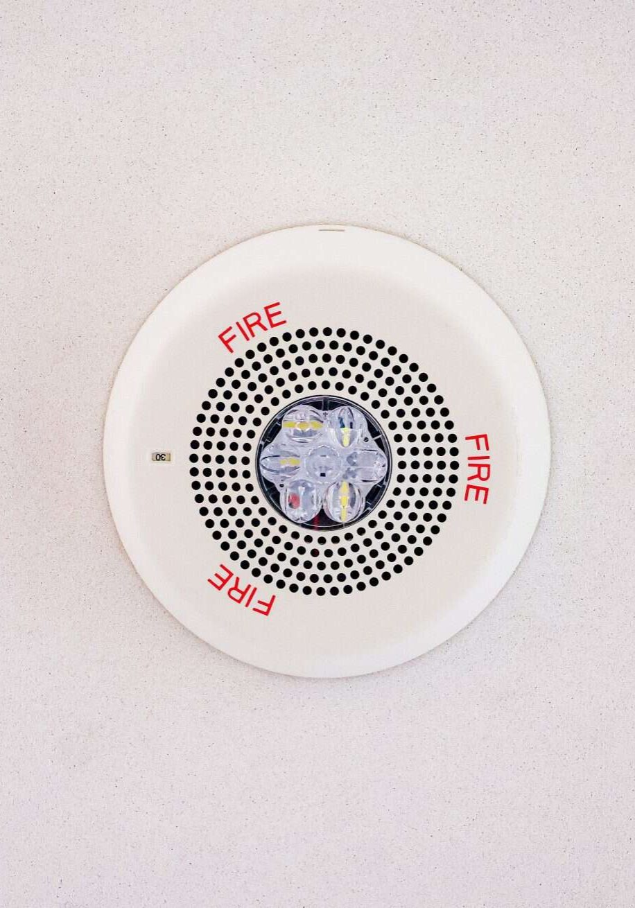 Ceiling-mounted fire alarm with LED indicator for early warning in commercial buildings.