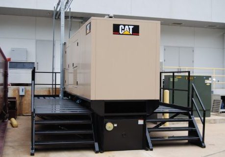 Industrial Caterpillar generator for commercial use, elevated with safety stairs.